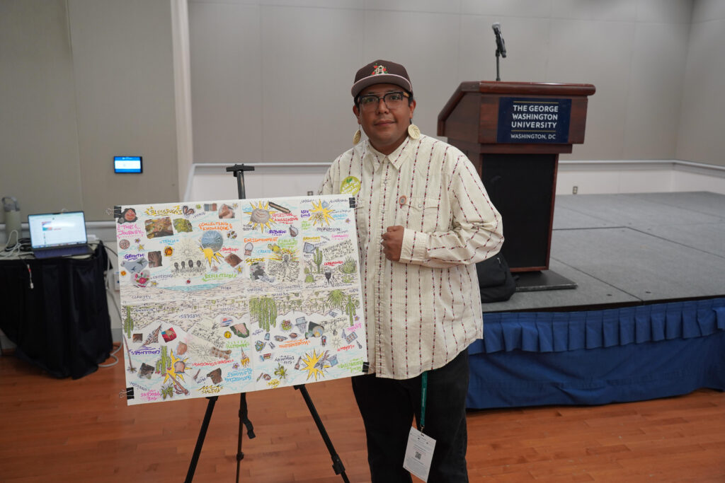 ICP Correspondent Derrick Gonzalez standing beside his zine reflecting on the salt run at the 2026 Planet Forward Summit.
